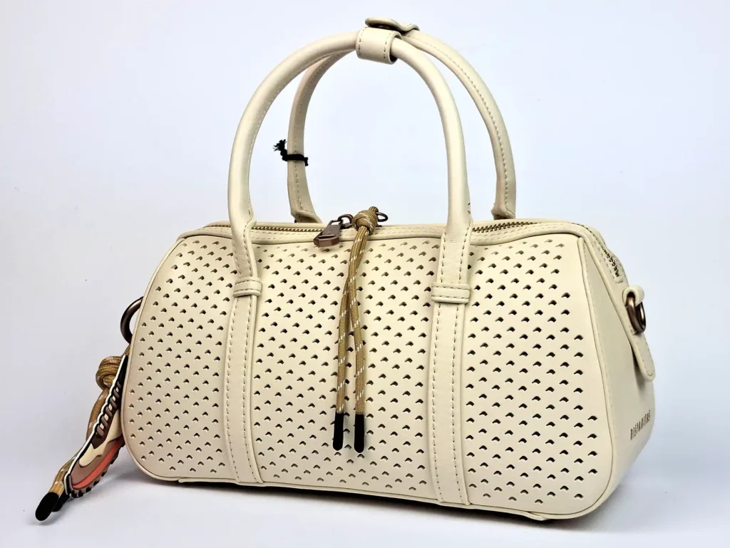 sommerliche Handtasche mit dekorativem Lochmuster Langer Henkel innen liegend, kann bei Bedarf mit Karabiner außen befestigt werden innen rosa Futter, zwei Innentaschen, eine mit Reißverschluss 30 x 12 x 15 cm (B x T x H)